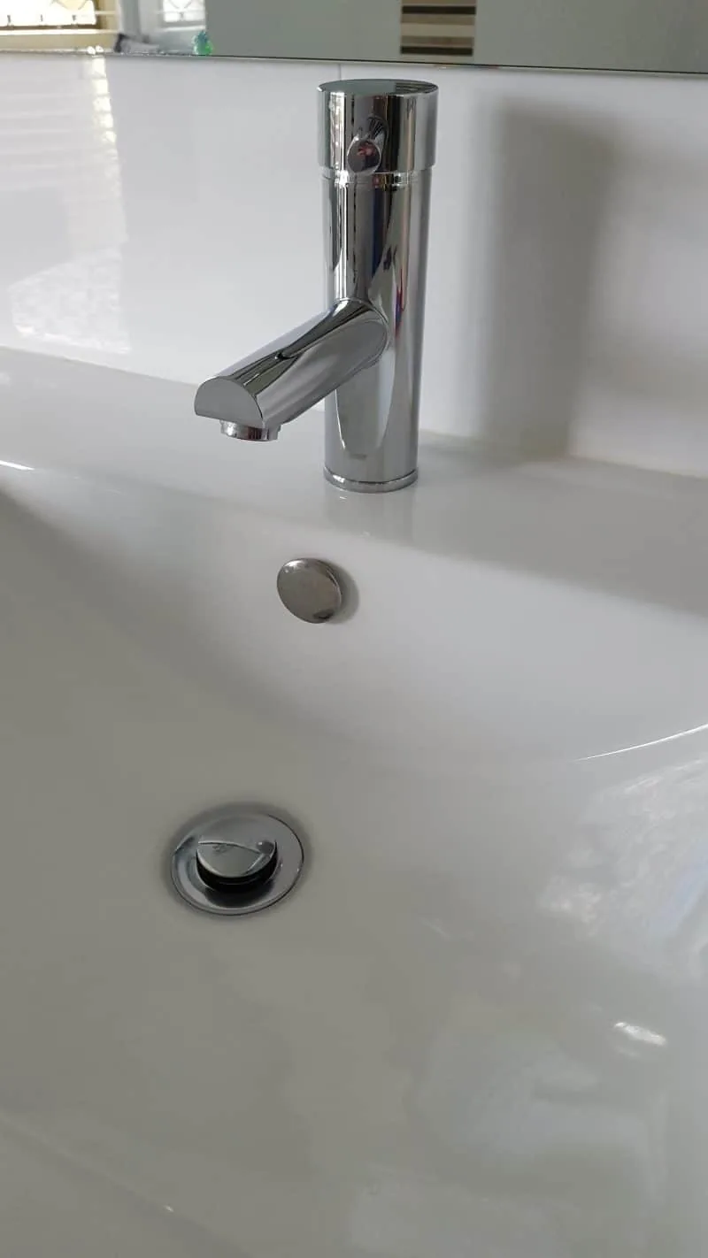 New chrome basin mixer and pop-up waste fitted to a white vanity basin
