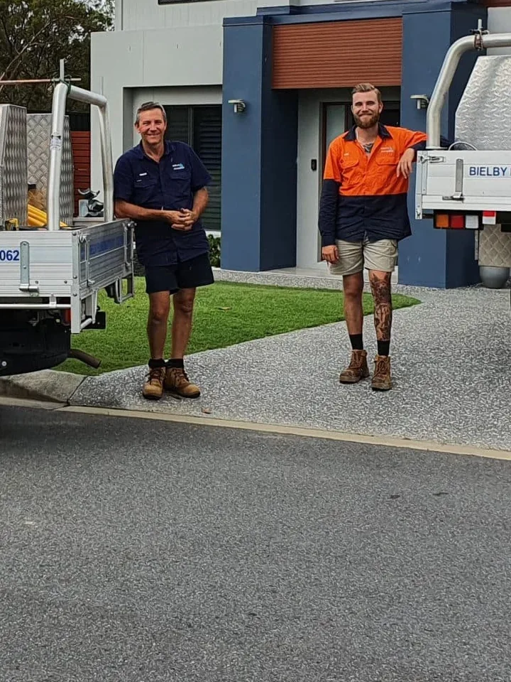 Two members of the Bielby Plumbing team standing beside a branded work ute
